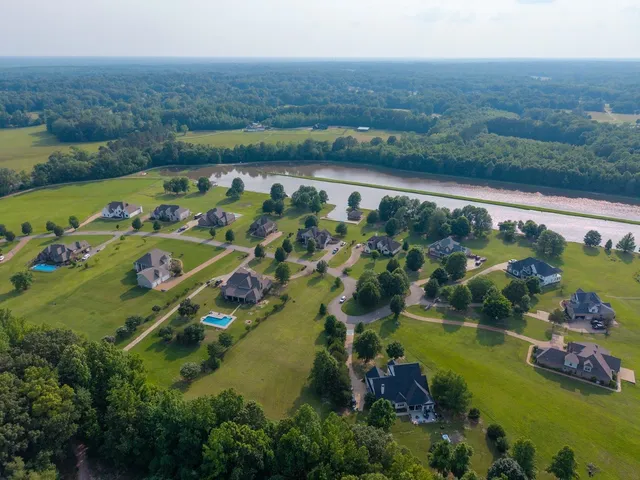 an aerial view of lake and residential houses with outdoor space