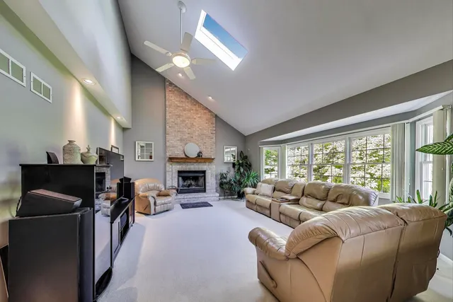 a living room with furniture a fireplace and a large window