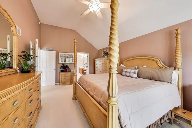 a bedroom with a large bed and a chandelier