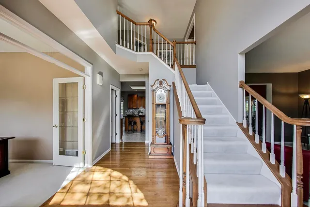 a view of staircase with lots of frames on wall and wooden floor