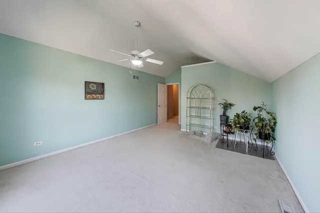 an empty room with windows and ceiling fan