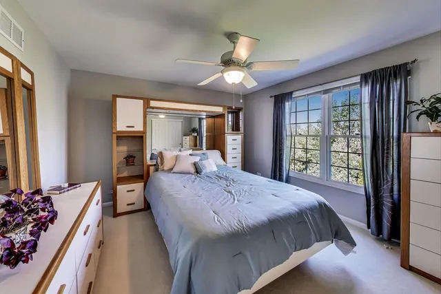 a bed sitting in a spacious bedroom next to a window