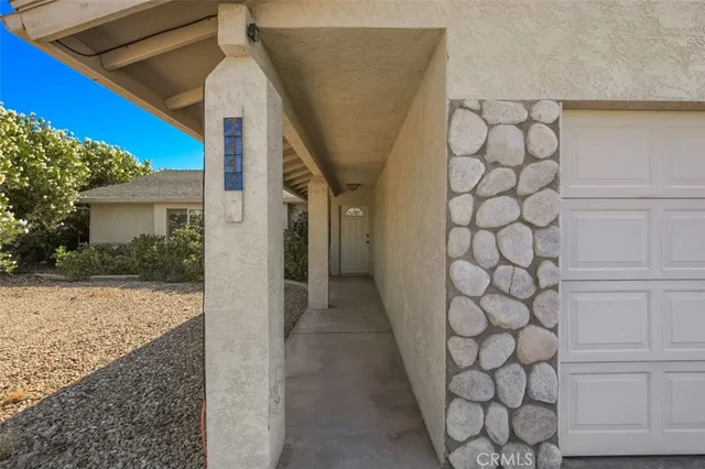 a living room with furniture and paintings on the wall
