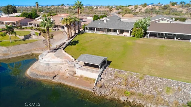 an aerial view of a house with a yard and lake view