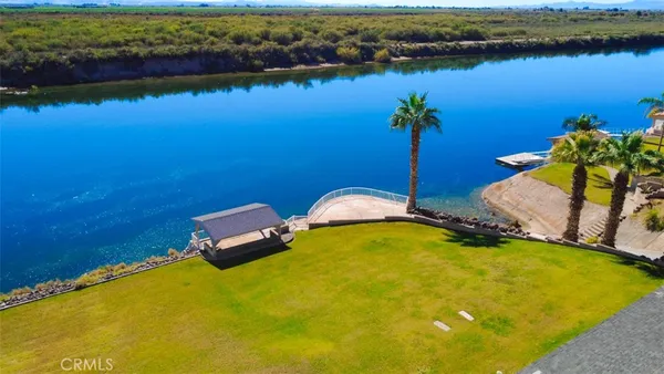 an aerial view of a house with a yard and lake view