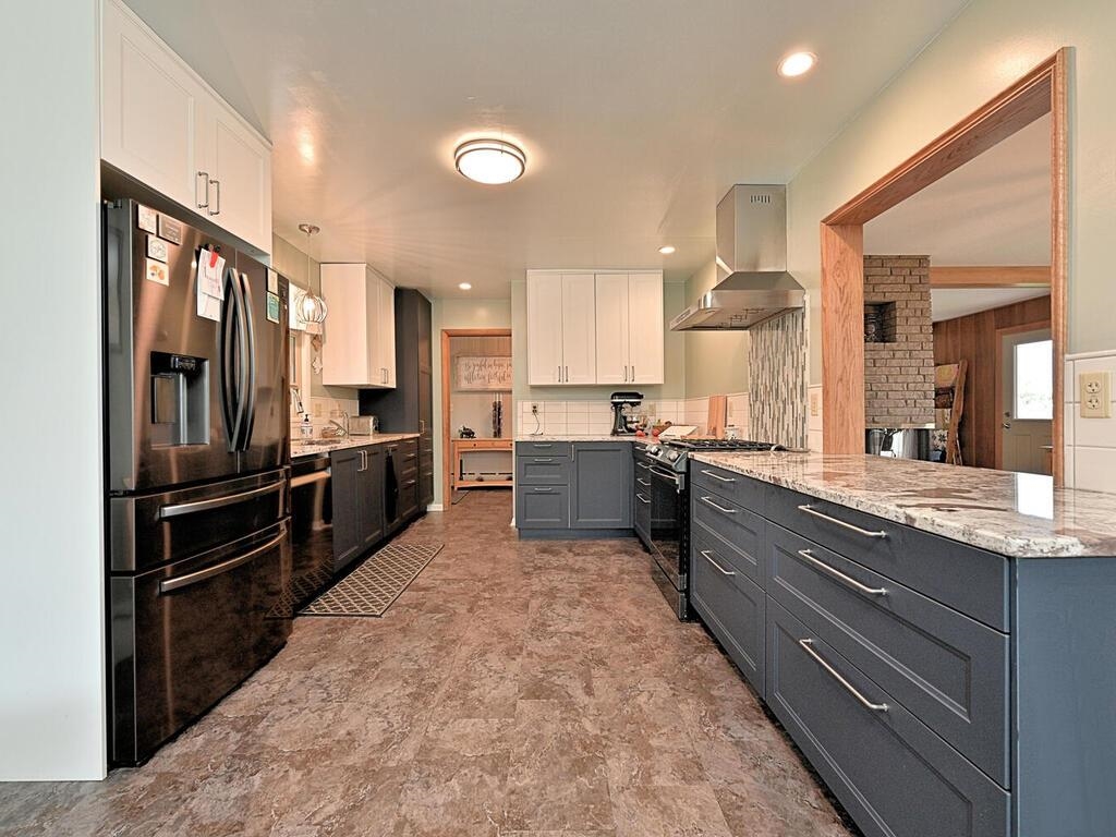 7 Kent Lane Silver Bay, MN 55614 - Photo 11 of 32 Kitchen with white cabinetry, stainless steel refrigerator with ice dispenser, exhaust hood, gas range, and gray cabinets