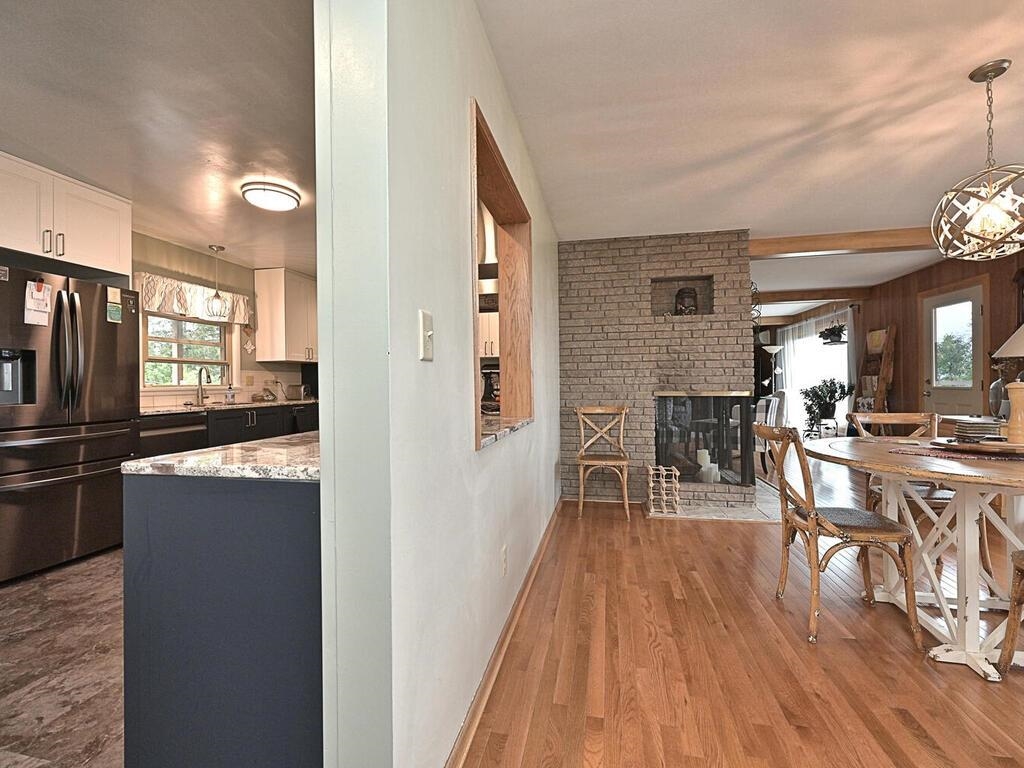 7 Kent Lane Silver Bay, MN 55614 - Photo 13 of 32 Dining space with healthy amount of natural light, a brick fireplace, dark wood-type flooring, and wood walls