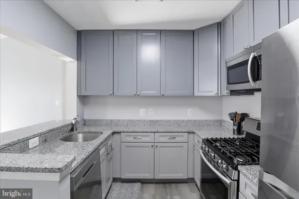 a kitchen with granite countertop a sink stove and cabinets
