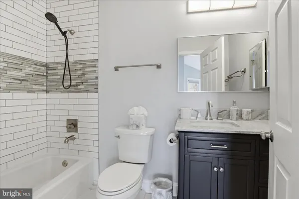 a bathroom with a granite countertop toilet sink and mirror