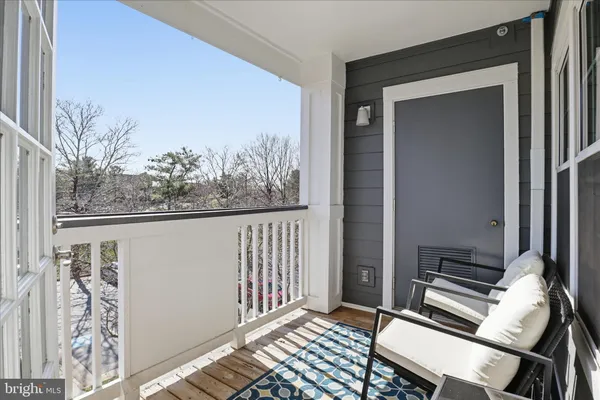 a view of a balcony with wooden floor and furniture
