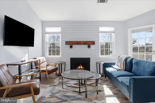 a living room with furniture a flat screen tv and a fireplace
