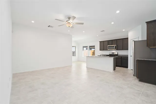 a view of kitchen with stainless steel appliances kitchen island a refrigerator sink and cabinets
