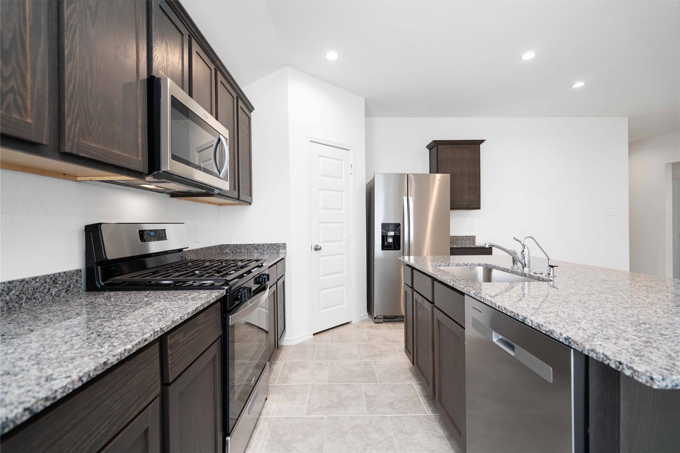 7507 Fierce Friesian Lane Rosharon, TX 77583 - Photo 5 of 9 a kitchen with stainless steel appliances granite countertop a sink a stove and a refrigerator