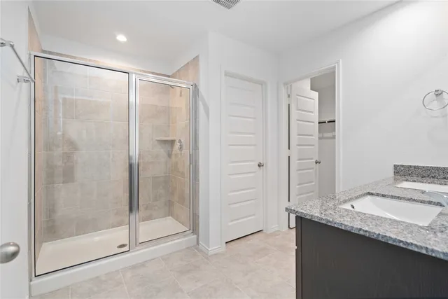 a bathroom with a granite countertop sink and shower