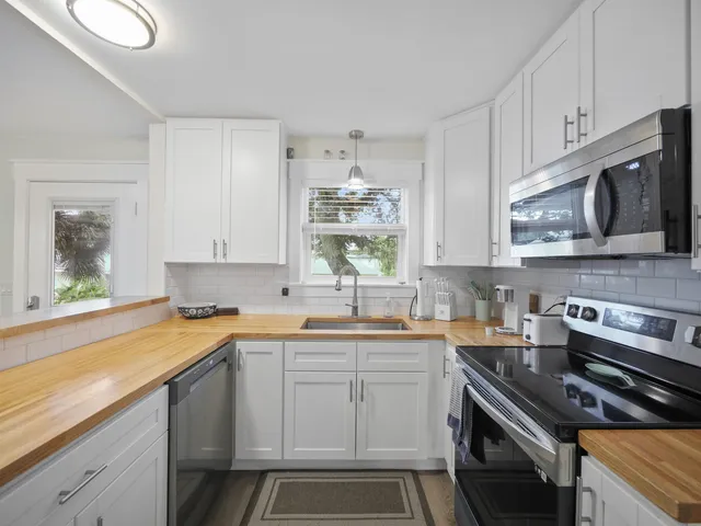 a kitchen with a sink stove top oven and cabinets