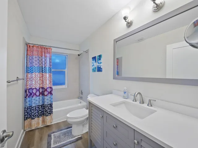 a bathroom with a granite countertop sink mirror vanity and toilet