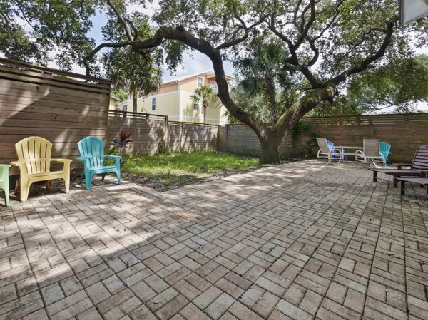 a view of backyard with table and chairs and a large tree