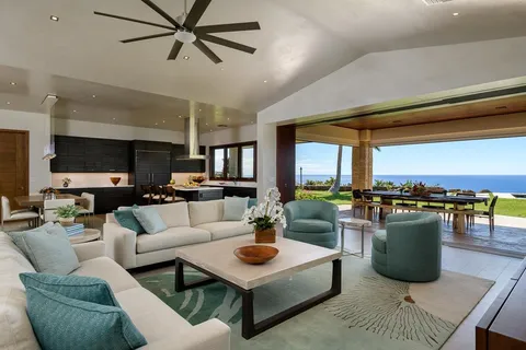 a living room with furniture a ceiling fan and a large window