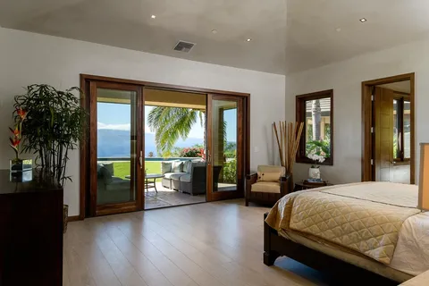 a bedroom with a large bed and a large window with wooden floor