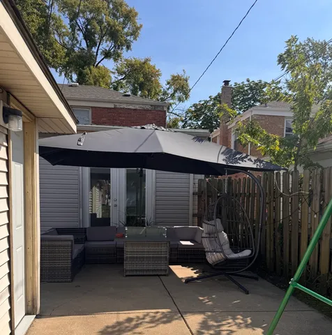 a view of a patio with table and chairs with wooden fence and plants
