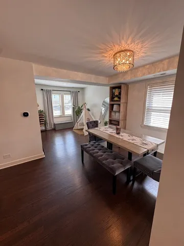 a living room with furniture a large window and wooden floor