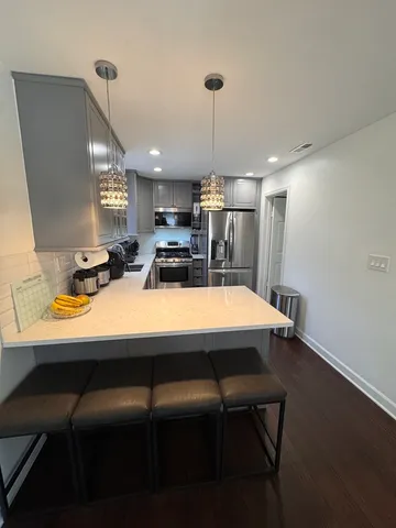 a kitchen with a table chairs refrigerator and microwave