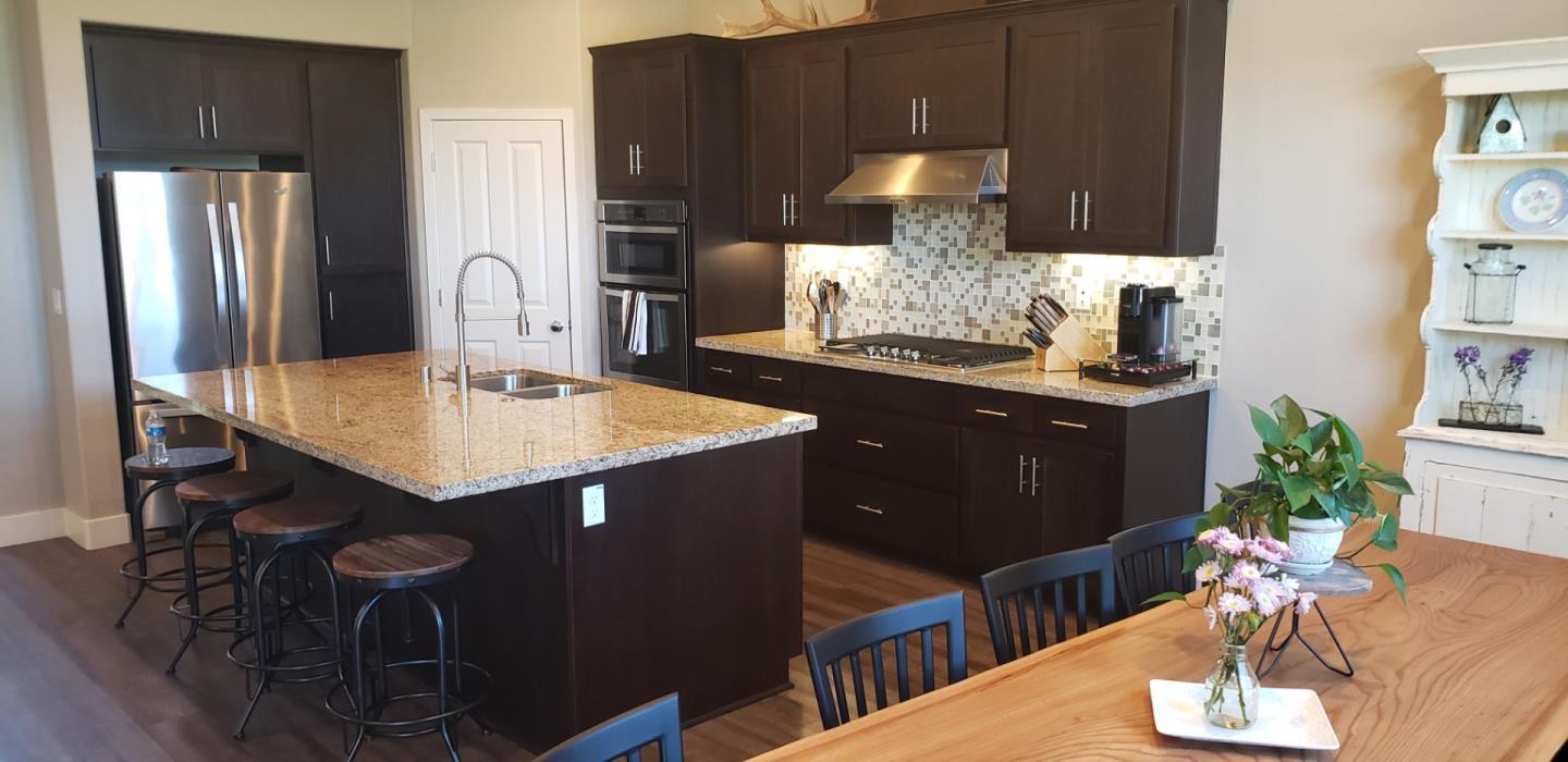 931 Puma Way Gilroy, CA 95020 - Photo 7 of 27 a kitchen with stainless steel appliances granite countertop a refrigerator a stove a sink dishwasher and microwave with wooden floor
