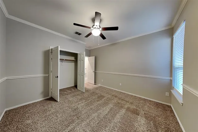 an empty room with closet and windows