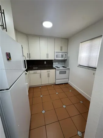 a kitchen with a sink a stove and cabinets