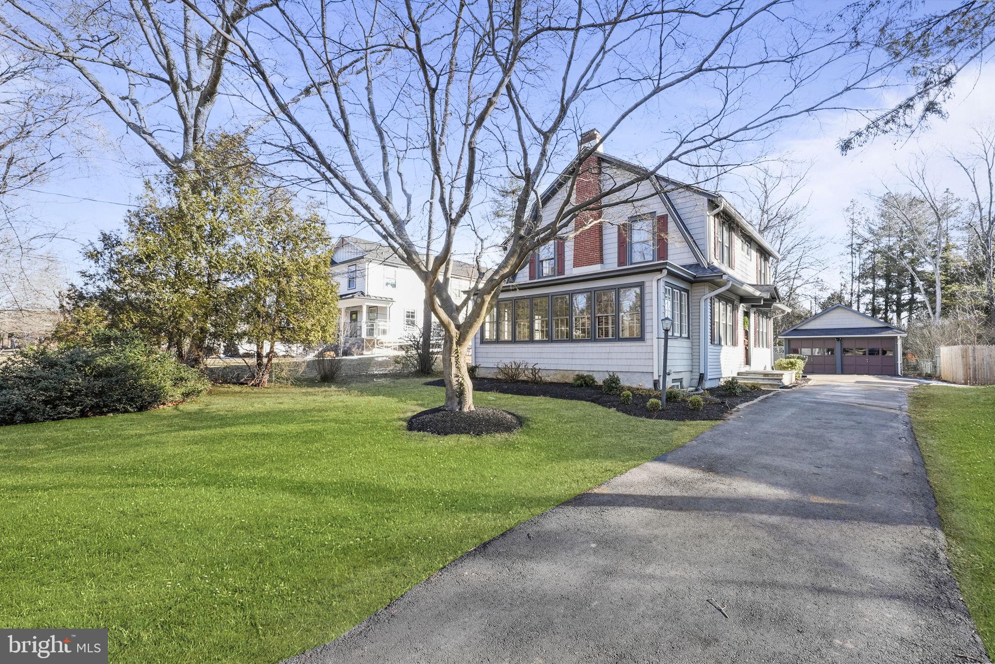 a front view of a house with a garden and trees