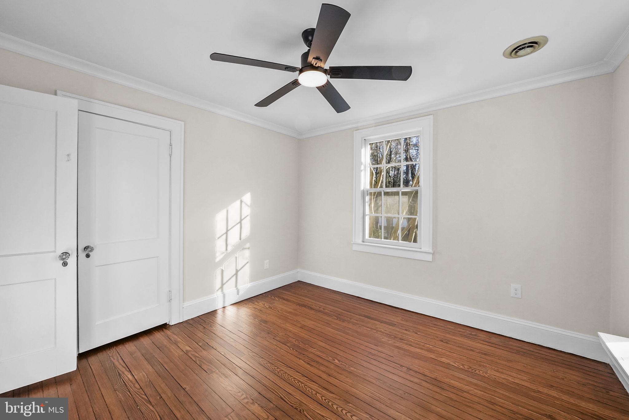 2046 Pennington Road Ewing, NJ 08618 - Photo 27 of 37 an empty room with wooden floor ceiling fan and windows