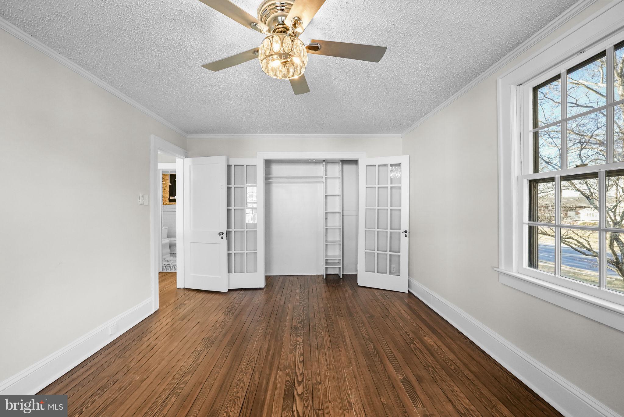 2046 Pennington Road Ewing, NJ 08618 - Photo 33 of 37 an empty room with wooden floor chandelier fan and windows