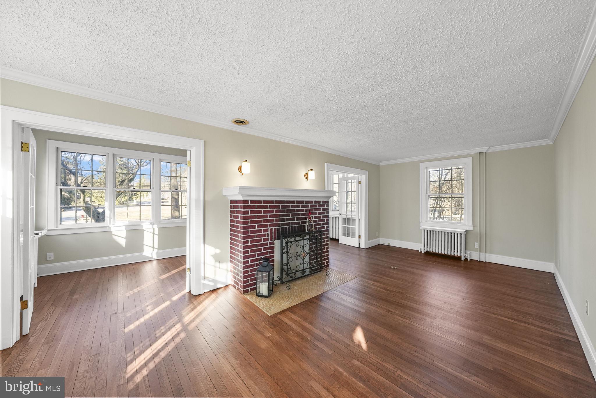 2046 Pennington Road Ewing, NJ 08618 - Photo 9 of 37 an empty room with wooden floor and fireplace