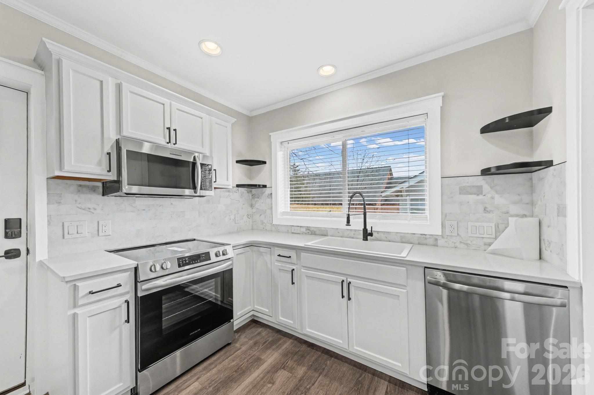 1132 East Main Street Albemarle, NC 28001 - Photo 14 of 25 a kitchen with stainless steel appliances granite countertop a sink stove and microwave