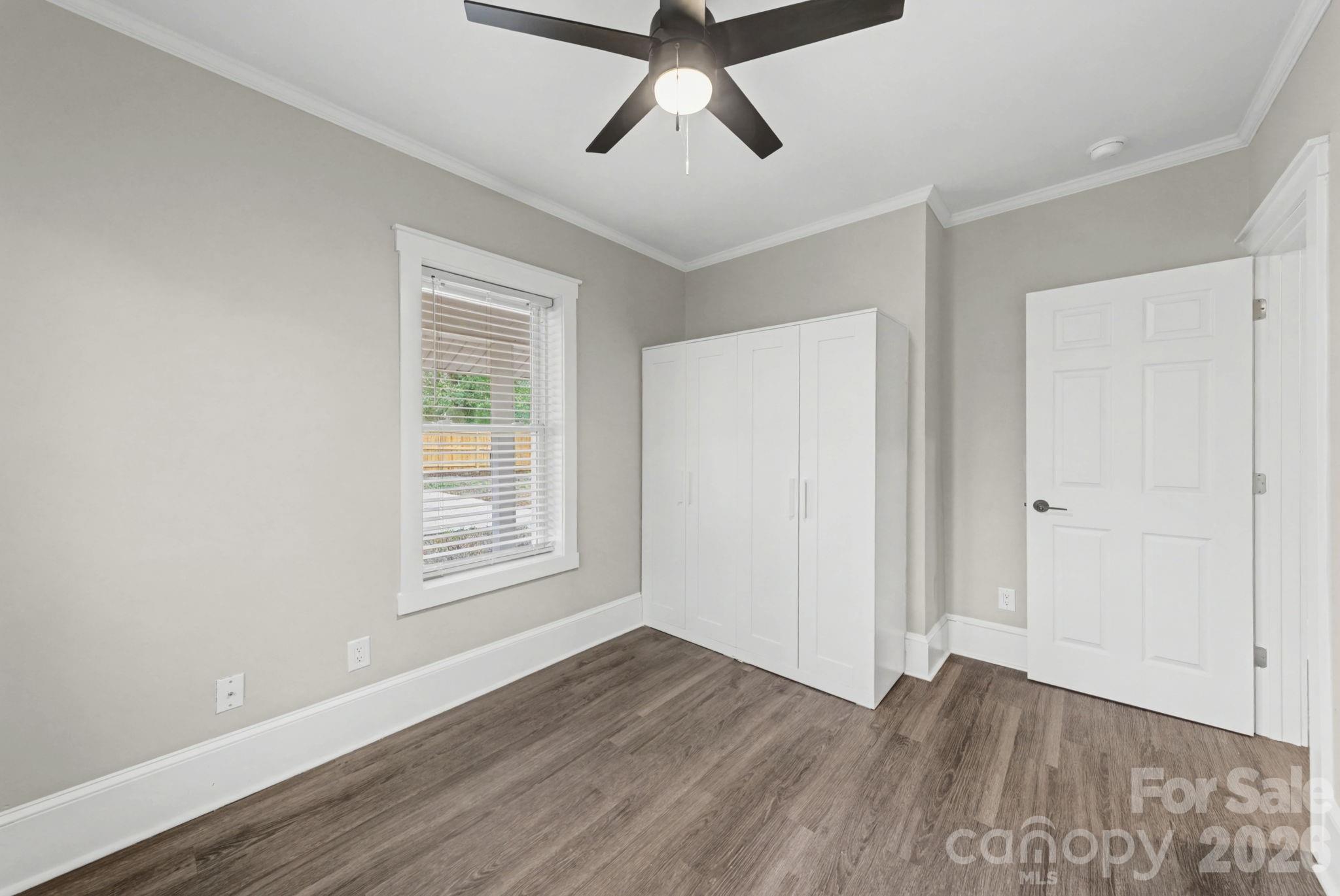 1132 East Main Street Albemarle, NC 28001 - Photo 17 of 25 a view of empty room with wooden floor and fan