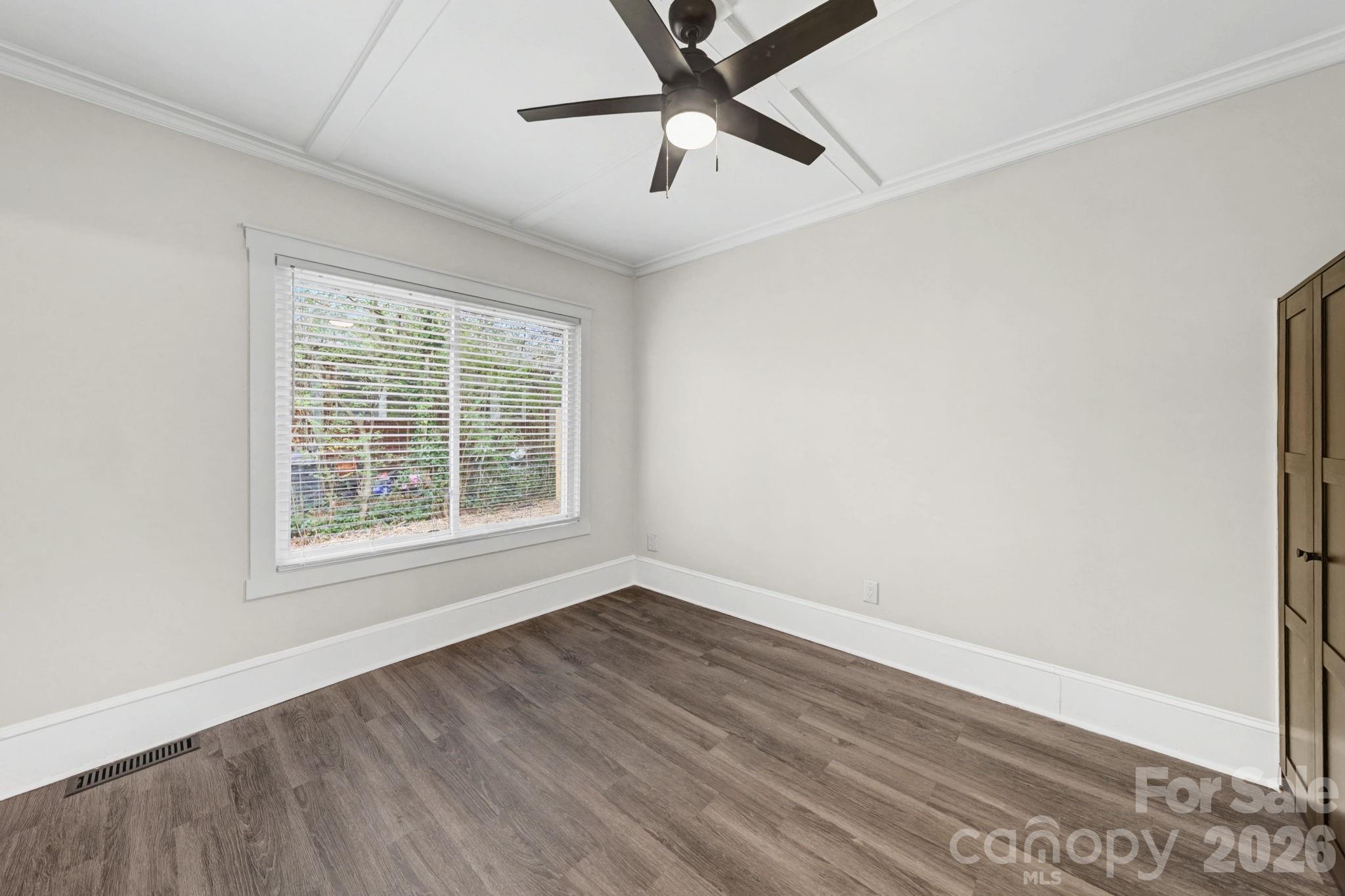 1132 East Main Street Albemarle, NC 28001 - Photo 19 of 25 a view of an empty room with wooden floor and a window