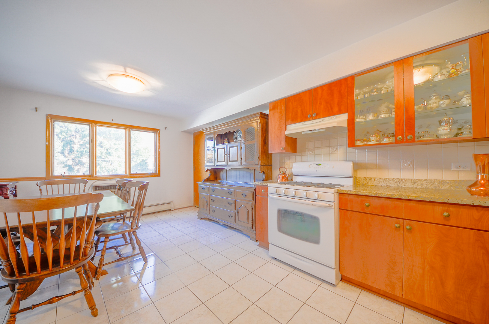 8216 West Belmont Avenue, Unit 2N Chicago, IL 60634 - Photo 4 of 11 a kitchen that has a lot of cabinets in it with a dining table and chairs