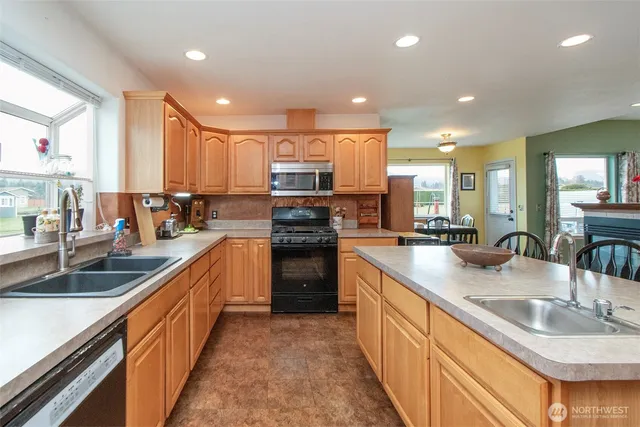 a kitchen with stainless steel appliances granite countertop a sink stove and cabinets