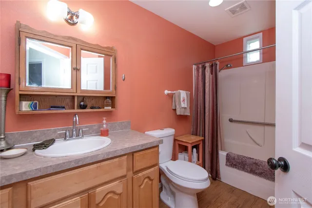 a bathroom with a granite countertop sink toilet a mirror and shower