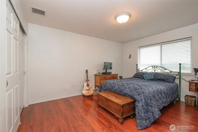 a bedroom with a bed and wooden floor