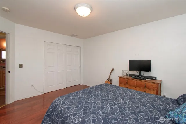 a bedroom with bed and flat screen tv