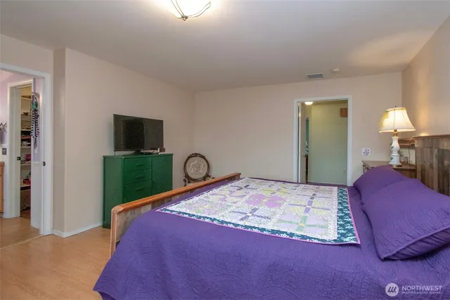 a bedroom with a bed and a flat screen television