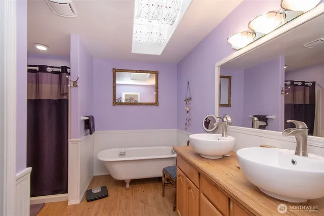 a bathroom with a granite countertop sink a toilet a mirror and bathtub