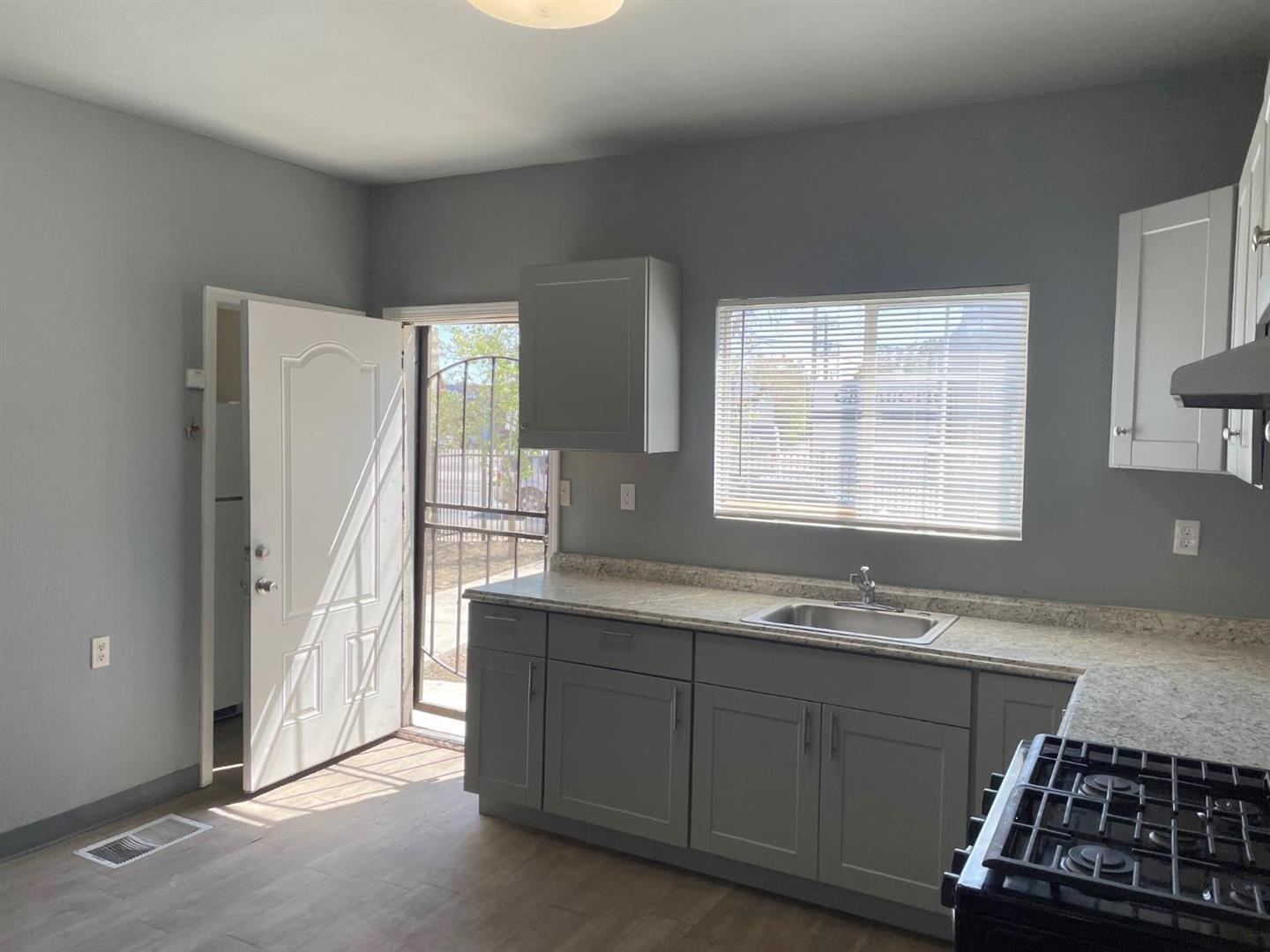 1217 East Harding Way Stockton, CA 95205 - Photo 2 of 5 a kitchen with a sink stove and cabinets