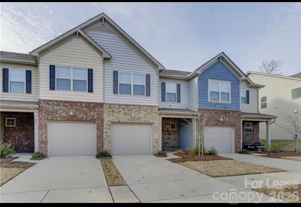 a front view of a house with a garage and a yard