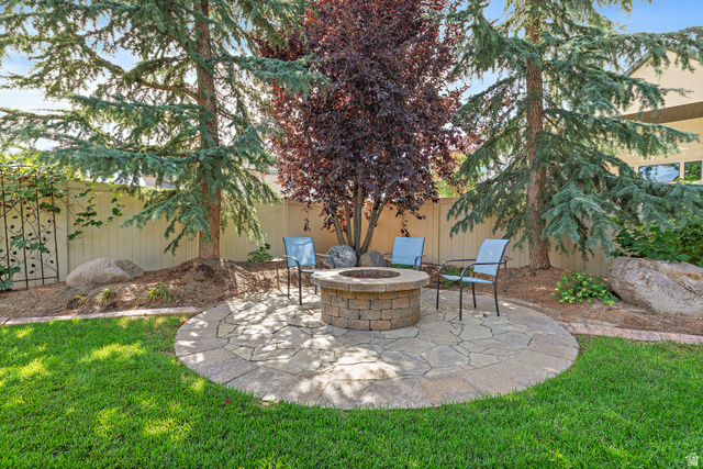 552 East Johns Way Sandy, UT 84070 - Photo 58 of 67 Landscaped backyard featuring a stone-paver patio, built-in fire pit, and mature trees