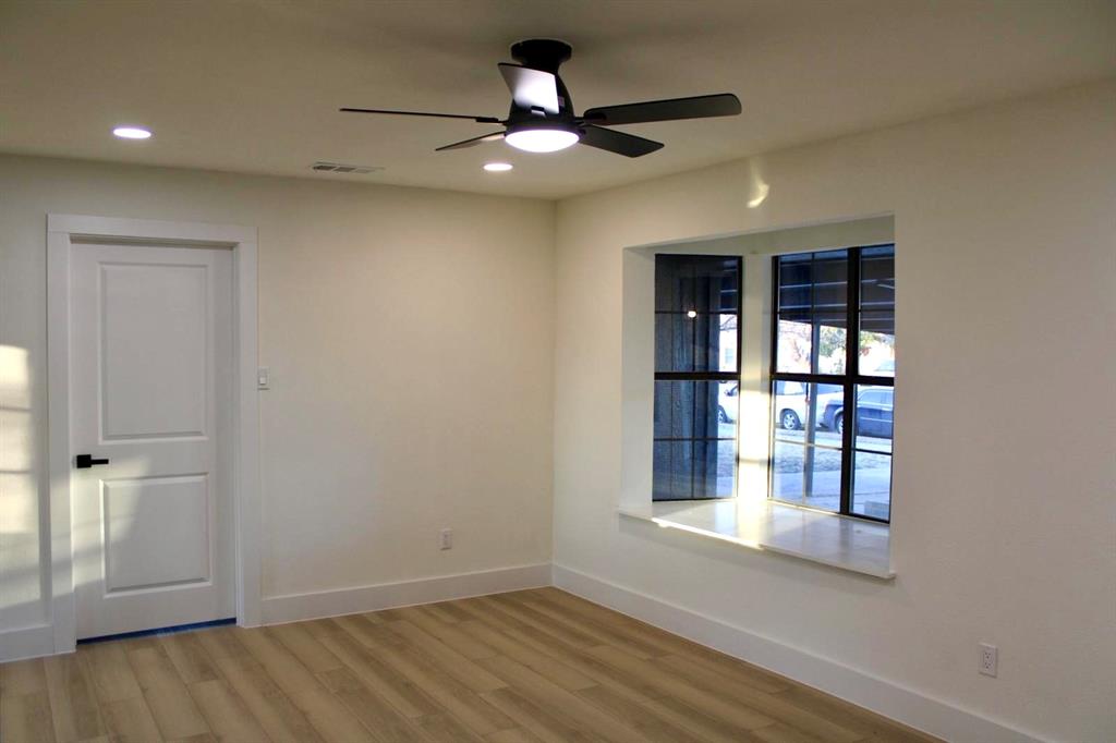 4211 Ridgedale Drive Mesquite, TX 75150 - Photo 7 of 11 an empty room with wooden floor and windows