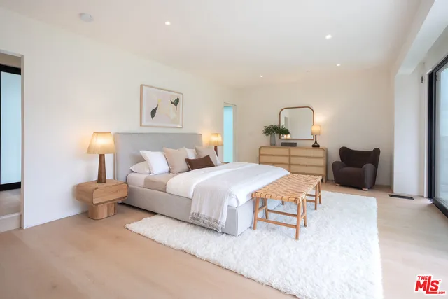 a spacious bedroom with a bed and a lamp