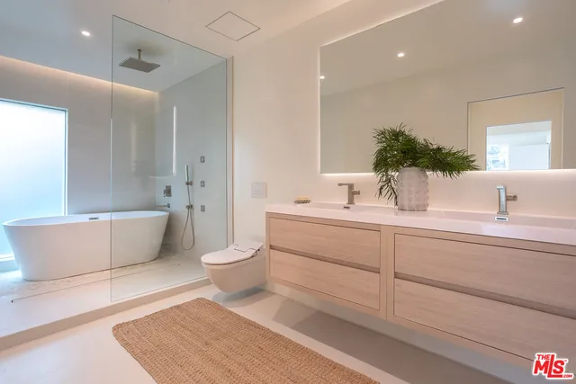 a bathroom with a toilet a sink a mirror and bathtub