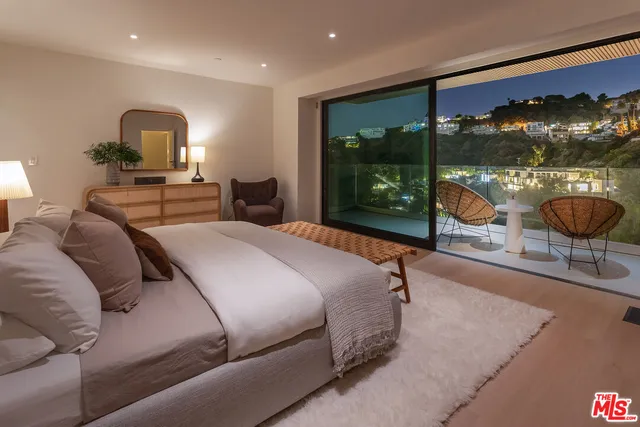 a bedroom with a bed and large window